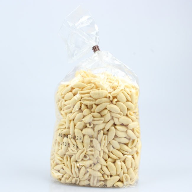 Primo piano di cavatelli Lucanella trafilati al bronzo, pasta artigianale dalla forma caratteristica e dalla superficie ruvida ideale per raccogliere sughi e condimenti.